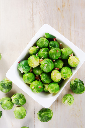 Close up Aerial Shot of Fresh Brussels Sprouts on Bowl on Top of Wooden Table.の写真素材