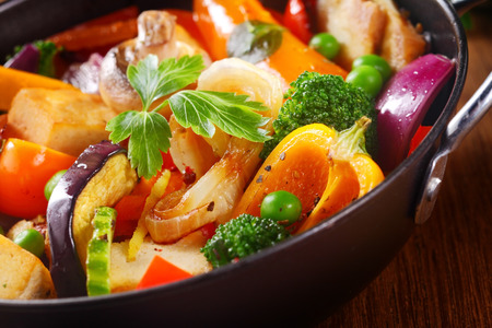 Close up Herbs on Top of Healthy Cooked Main Dish on Black Cooking Pan, Placed on Wooden Table.の写真素材