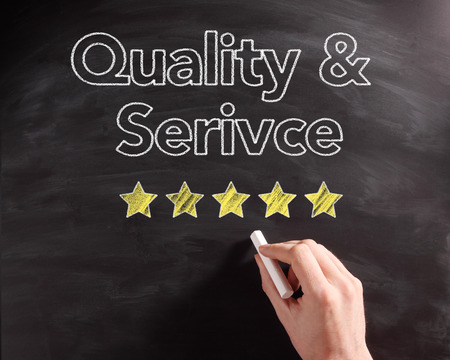 Conceptual Handwritten Service and Quality Texts on Black Chalkboard with Five Stars Drawing.の写真素材