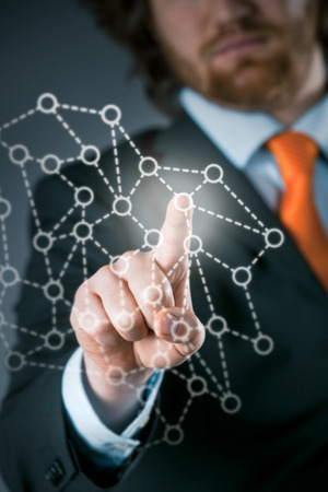 Businessman using a network on a virtual interface activating a group or community of networked contacts in a communication conceptの写真素材