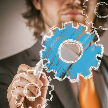 Businessman Drawing Blue and White Conceptual Gears in Close up, on Glass Board Using Marker.の写真素材