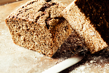 Loaf of delicious freshly baked crusty wholegrain brown bread cut through the center to reveal the...