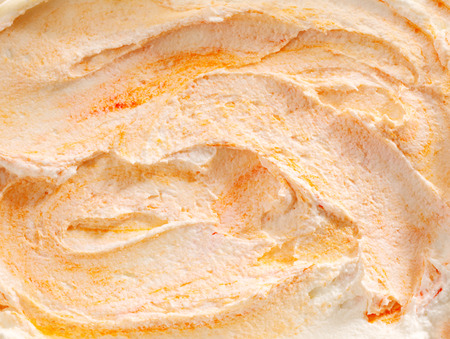 Delicious tangy Italian orange ice cream background texture with an overhead closeup view of the swirled surface of the dessertの写真素材