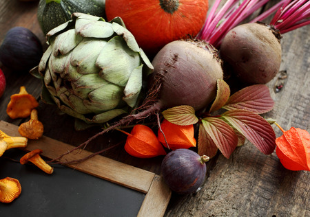 Autumn still-life with fresh vegetables including artichoke beetroot and squash or pumpkin arranged...