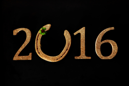 2016 New Year background wishing you Good Luck with a golden horseshoe incorporated into the date...