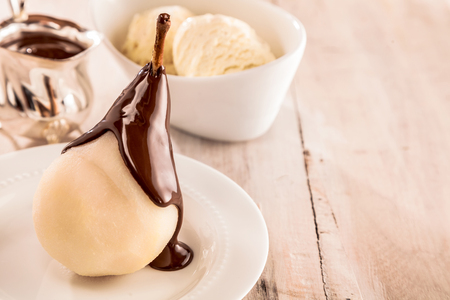 Whole fresh pears called Birne Helene with chocolate sauce and ice-cream as a side dish served for a tasty dessert. close up viewの写真素材