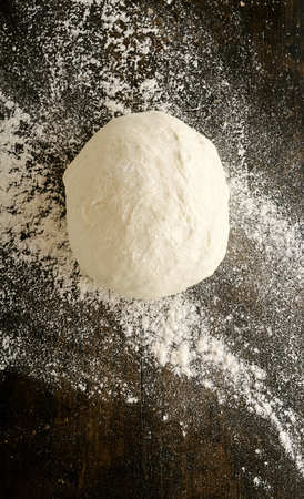 Mound of freshly made dough left to stand on a kitchen counter with a scattering of surrounding...