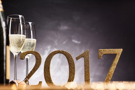 Celebrating the 2017 New Year with flutes of champagne over a sparkling bokeh of party lights...