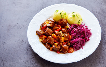 Herbed potato dumplings served with spicy beef and braised purple cabbageの写真素材