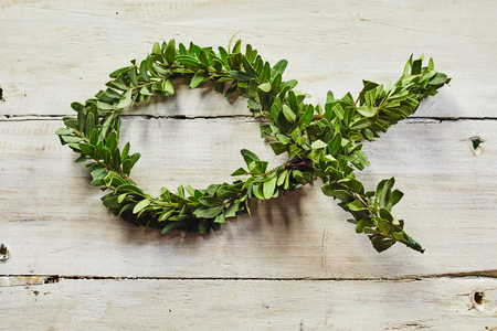 Christian fish symbol Ichthys on white background. Decorative floristic floral arrangement on wooden plate for holy communion celebrationsの写真素材