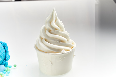 Close Up Still Life of Vanilla Soft Serve Ice Cream in Paper Take Out Cup in front of White Backgroundの写真素材