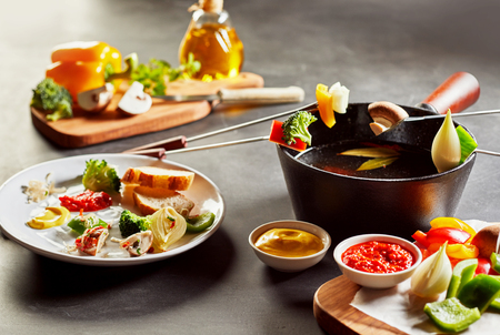 Fresh farm vegetables for a healthy fondue dinner served with crusty bread and dipping sauces for vegetarian and vegan themed mealsの写真素材