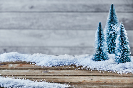 Christmas seasonal background with copy space and winter snow on rustic wood with snow-clad fir trees as a side borderの写真素材
