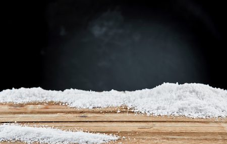 Winter card with close-up of snow on a wooden rustic board against black background for copy spaceの写真素材