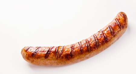 Side view of curved single German bratwurst sausage on white background.の写真素材