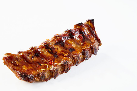 Barbecued and marinated sticky spare ribs on a white background with copy space.の写真素材
