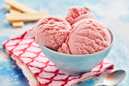 Creamy scoops Italian strawberry gelato or ice cream served in a blue bowl for a delicious refreshing summer dessert in a close up viewの販売画像