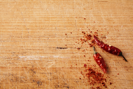 Red chili pepper pods and cayenne spice in the corner on a rustic wooden background with copy space in a food and cooking conceptの写真素材