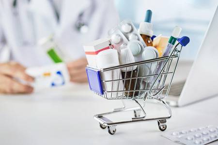 Close up view of mini shopping cart with drugs in pharmacyの写真素材