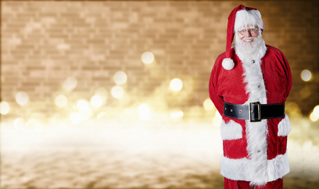 Festive Christmas background with a jolly smiling Santa Claus over a bright sparkling bokeh of party lights and copy space for a seasonal greetingの写真素材