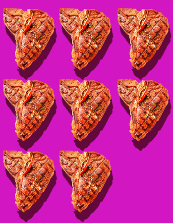 Eight grilled marinated T-bone steaks with hot red chili pepper garnish on bright magenta background with copy space and drop shadowsの写真素材