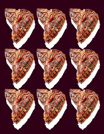 Nine grilled T-bones with herbs and chili seasoning with white drop shadows on a black background arranged neatly in three rowsの写真素材