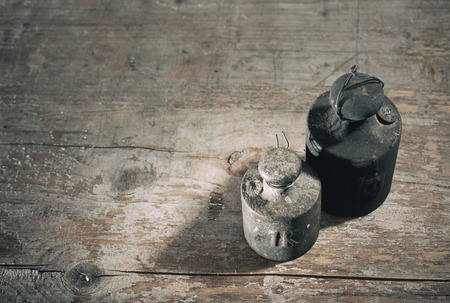 Two old dirty weights or measures for manual weighing on a scale on a rustic wood  with copy spaceの写真素材