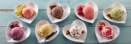 Scoops of different ice cream flavors in individual heart-shaped bowls with accompanying fresh...