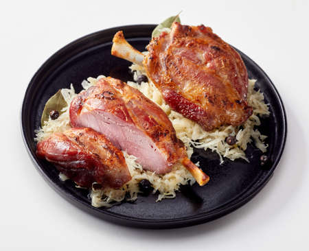 Double portion of traditional roasted German Eisbein or pork ham hock on sauerkraut served on a...