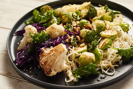 High angle of fresh raw cut chicken liver with cartilages in wooden pet bowl placed on table with uncooked ripe veggiesの写真素材