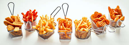 High angle of different types of French fries placed near roast chicken served with lettuce leaves...