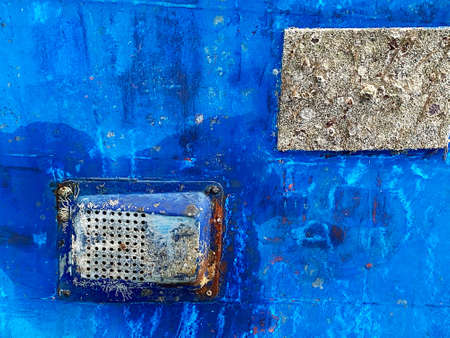 Corroded metal parts with rust on blue painted wall of aged shabby constructionの写真素材