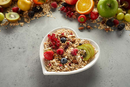 From above of delicious breakfast bowl with oat and ripe sweet fruits and berries served on tableの写真素材