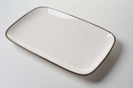 Large rectangular ceramic platter with dark rim for placement of meat for menu advertising in a...