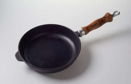 From above cast iron frying pan with polished lumber handle placed on gray backgroundの写真素材