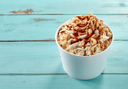 Hazelnut topping on a tub of vanilla ice cream spaghetti drizzled with caramel sauce for a tasty...