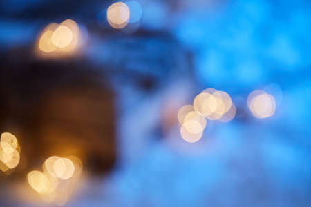 Defocused background of yellow bokeh lights of garland glowing brightly at night in winter during Christmas holidayの写真素材