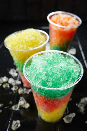 Assorted fresh slush drinks in plastic glassesの写真素材
