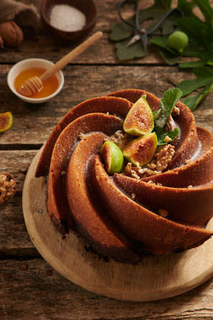 From above of sweet freshly bake cake made of figs with creative decoration served on cutting board in light kitchenの写真素材