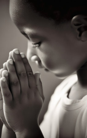 Generative AI black and white image of side view of crop African American innocent kid with closed eyes praying with hang together while standing in daylightの素材