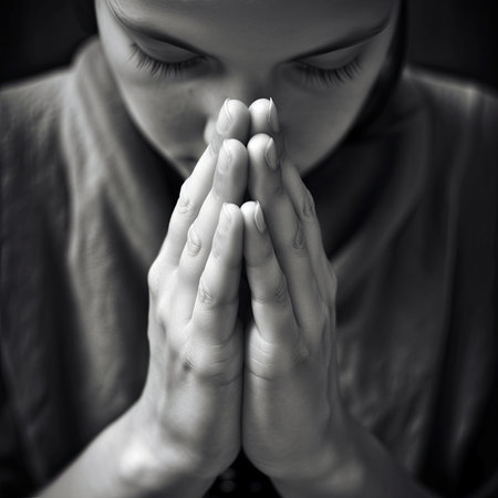 Generative AI image black and white portrait of crop young woman with closed eyes and clasped hands praying on black backgroundの素材