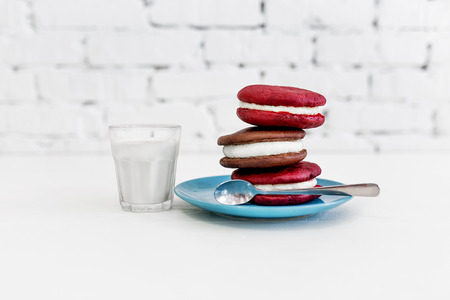 Image of three whoopie pies or moon pies with glass of milk and spoon.の写真素材