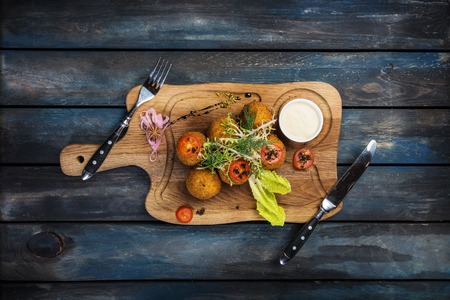 Deep fried beef meat balls in breadcrumbs with cheese sauce