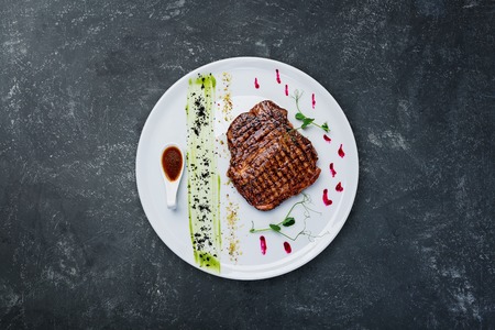 Grilled beef steak on a white plate.の写真素材