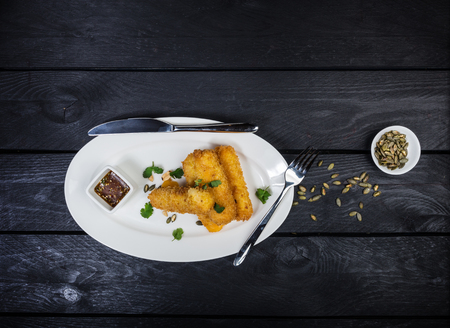 Cheese sticks served on white plate with sauce.の写真素材