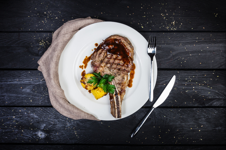 Rib-eye steak with corn. On the wooden background. Top view.の写真素材