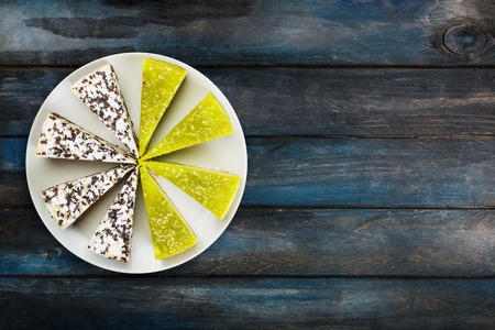 Two kinds of cheesecake chocolate and lime on a white dish, on a beautiful wooden background. Top view, with the copy space for your text.の写真素材