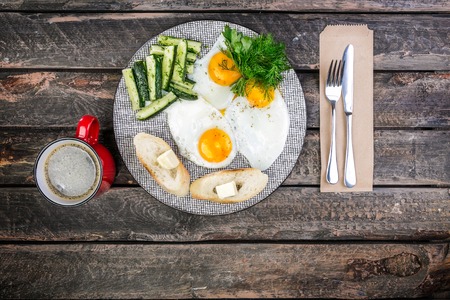 Tasty breakfast in the morning. Scrambled eggs and pickled cucumbers and salad with sauerkraut. Served by cutlery, with bread, butter and filter coffee. Top viewの写真素材