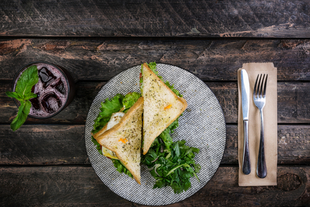 Sandwich with chicken and vegetables on a ceramic plate. Served with cutlery and fresh lemonade. Top viewの写真素材
