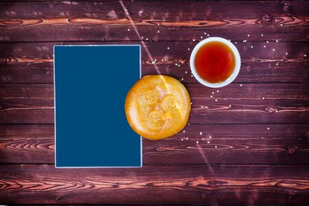 Traditional tandyr bread of Central Asia with tea on a wooden background with place for text. Top...